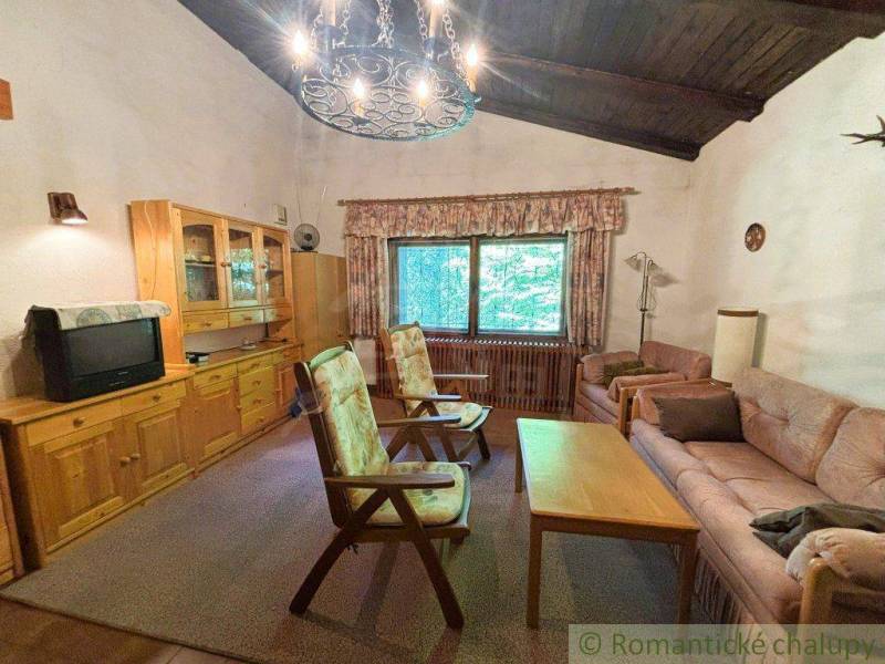 Living room with wooden furniture in a family house, comfortable seating and a vintage television.