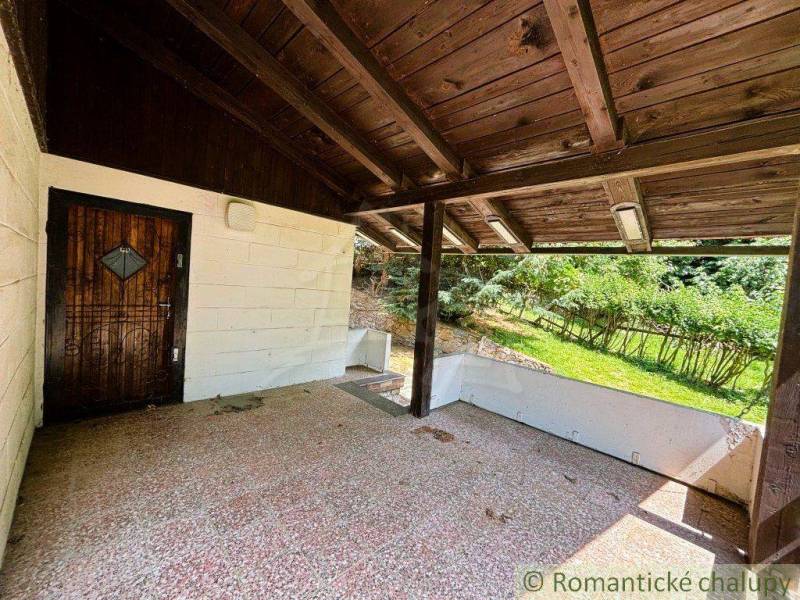 A family house in Malacky with a covered terrace, wooden ceiling, and a garden in the background.