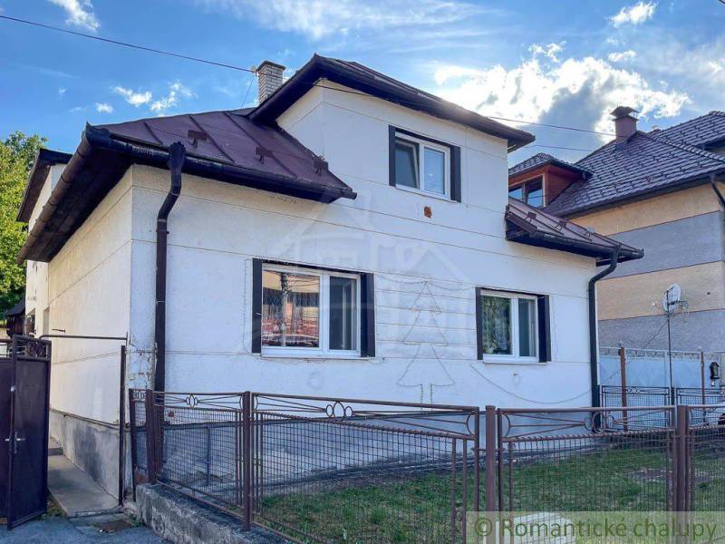A family house in Sielnica with a white facade and a sloped roof.