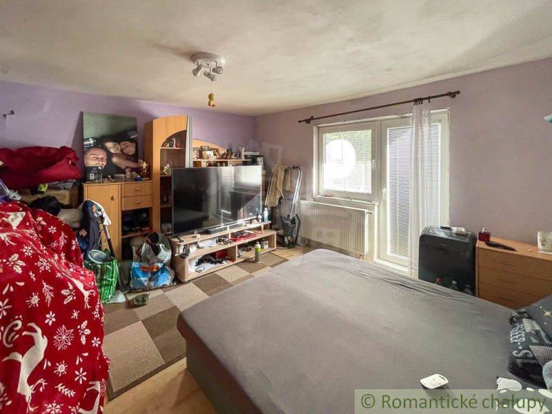 Living room in a family house with a sofa, television, and wall decorations.