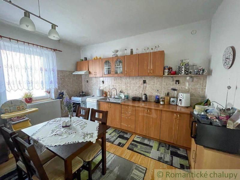 A kitchen in a family house with furniture, a dining table, and a kitchen unit.
