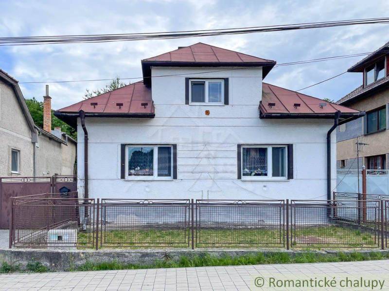 A family house in Sielnica with a metal roof and a metal fence.