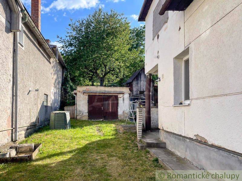 The courtyard of a family house in Sielnica with a shelter and a tree in the background.