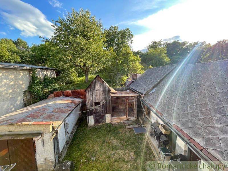 The courtyard of a family house in Sielnica with a garden and a wooden annex.