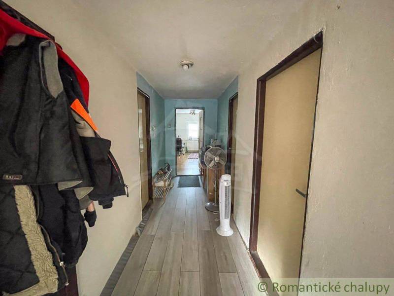 Hallway in a family house with coat racks, flooring, and fans.