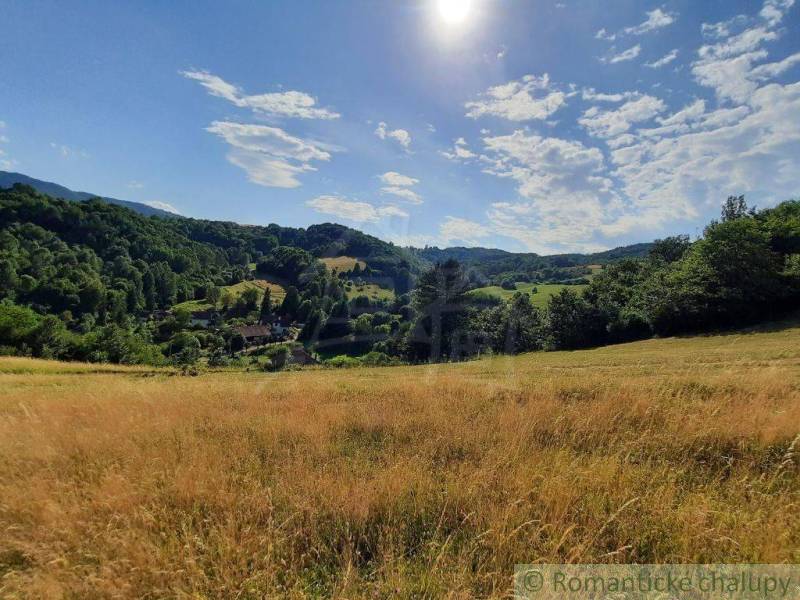 The landscape around Žarnovica, bordered by meadows and forests, under a blue sky.