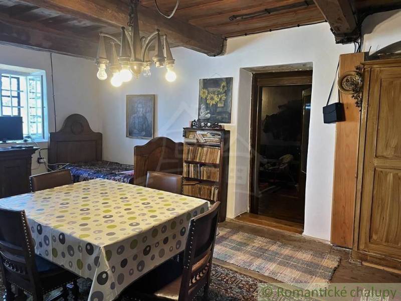 Rustic room with a wooden ceiling, dining table, and peculiar properties.