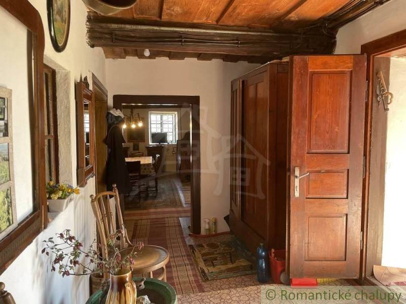 A traditional interior depicts unique properties with massive wooden doors and historical furniture.