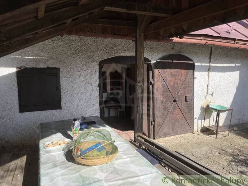 A veranda with wooden doors at a cottage in Rožňava with a table and a basket.