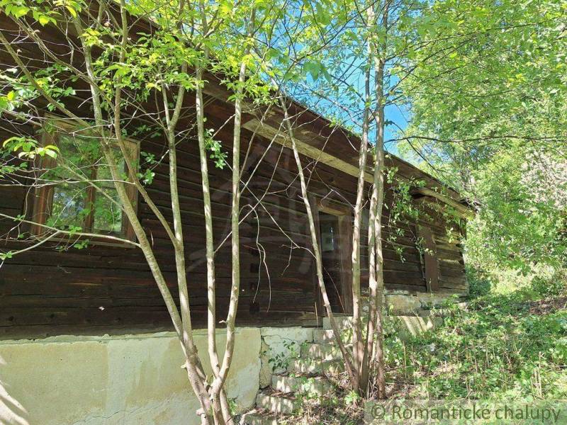 A wooden cottage in Liptovský Mikuláš surrounded by trees and greenery.