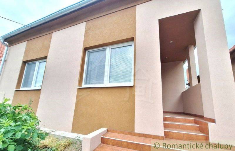 A family house in Komárno with entrance stairs and an elegant facade in two colors.