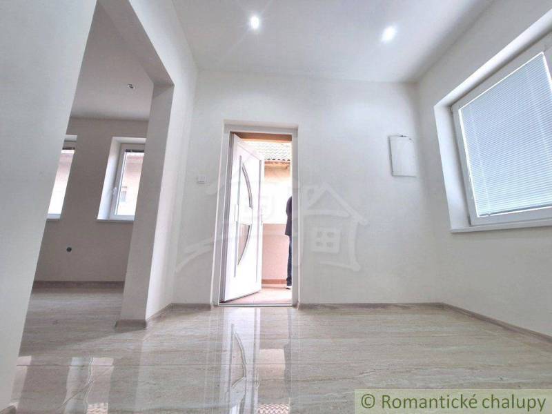 The interior of a family house with large windows and open white doors.