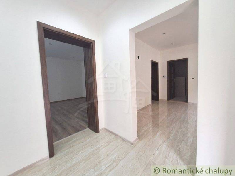 Interior of a family house with floating and light tiles, white walls, wooden frames.