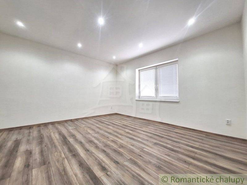 A spacious room with a wooden floor and a window in a family house.