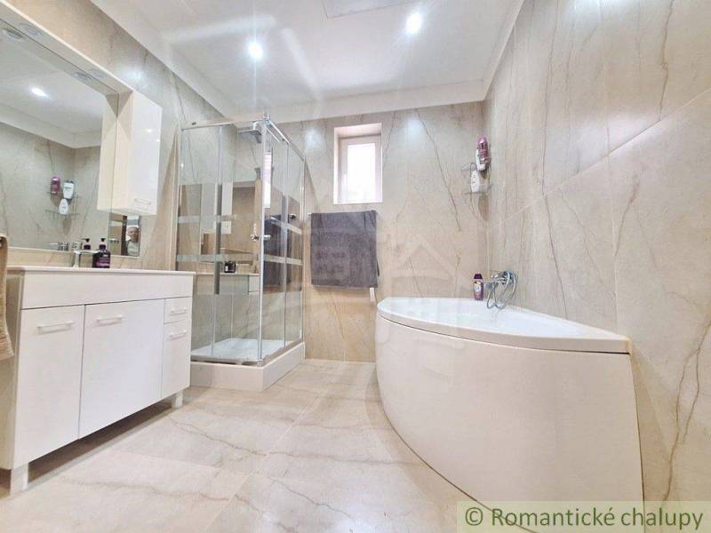 Bathroom with a bathtub and shower in a family house.
