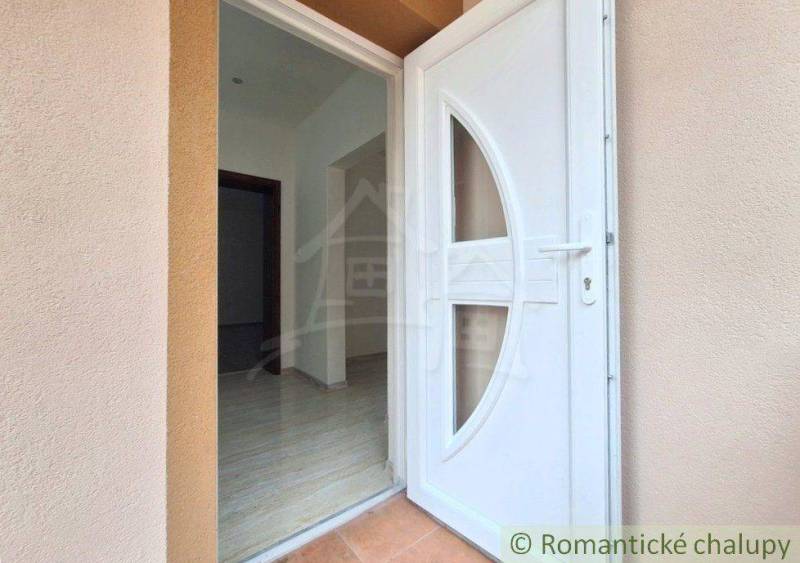 Entrance door to a family house in Komárno, with a tiled floor and a bright hallway.