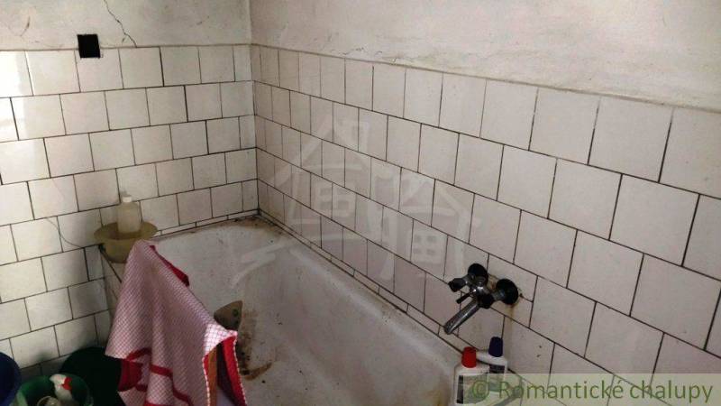 Bathroom with a tiled bathtub in a family house.