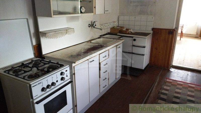 A kitchen in a family house with a gas stove and storage cabinets.