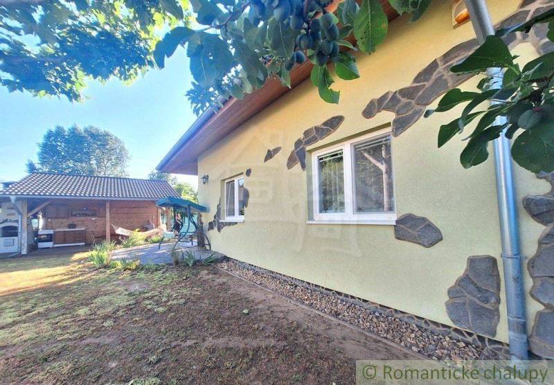 A family house in Komárno with a courtyard, garden furniture, and a barbecue shelter.