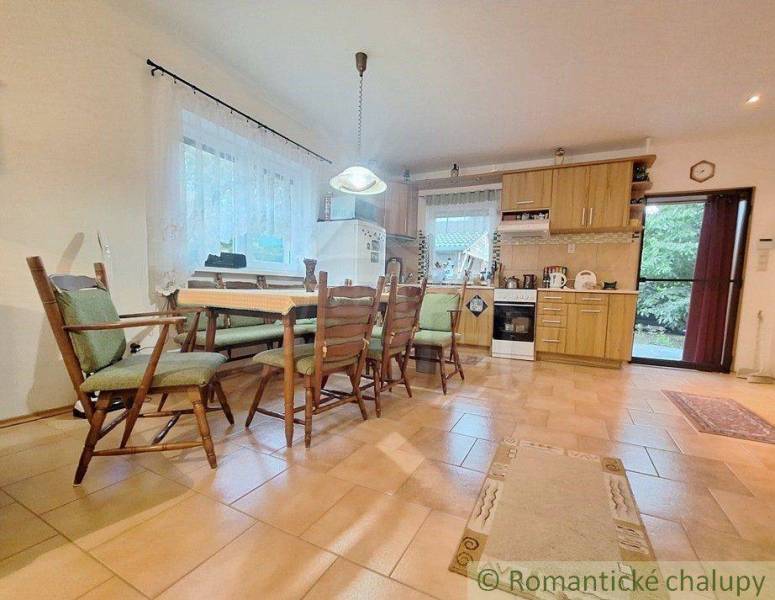 Interior in a family house with a kitchen unit, dining table, and chairs.