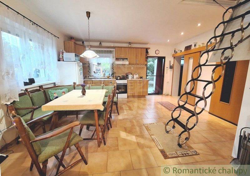 Dining room with stairs and kitchen in a family house.