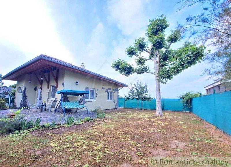 A family house in Komárno with a terrace, a swing, and a tree in the garden.
