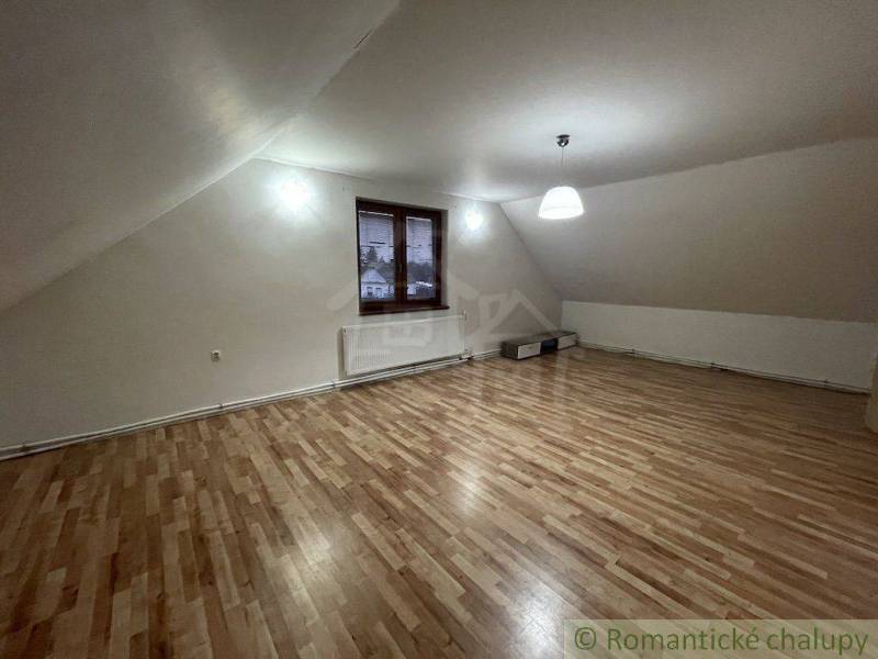 Attic room with a sloped ceiling, lighting and view, family house, wooden floor.