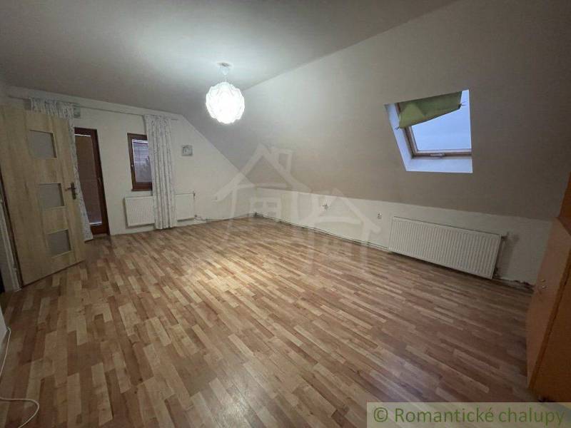 Attic room in a family house with laminate flooring and a skylight.
