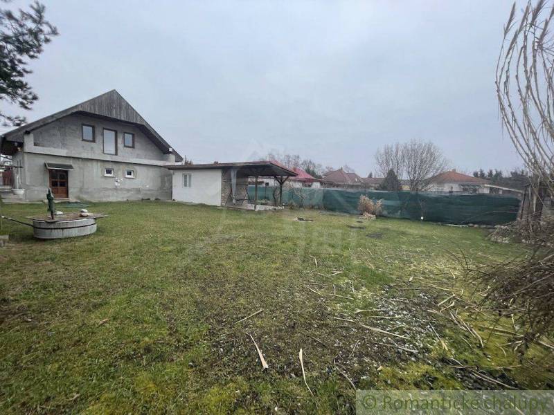A family house with a garden and a well in a peaceful rural location.