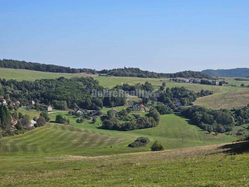 A hilly landscape with family houses in Malá Lehota, surrounded by meadows and forests.