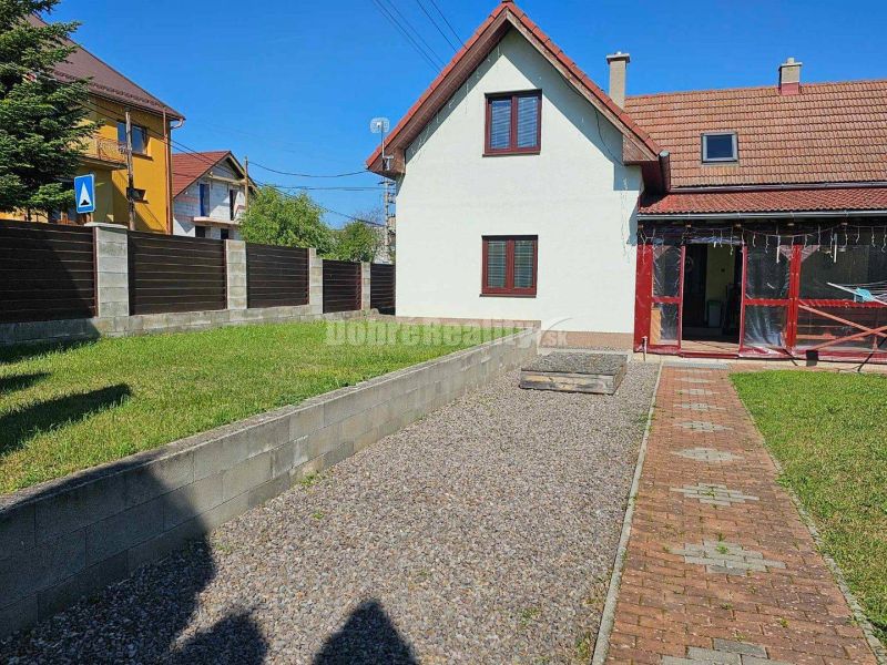 A family house in Malá Lehota with a garden, lawn, and paved path.