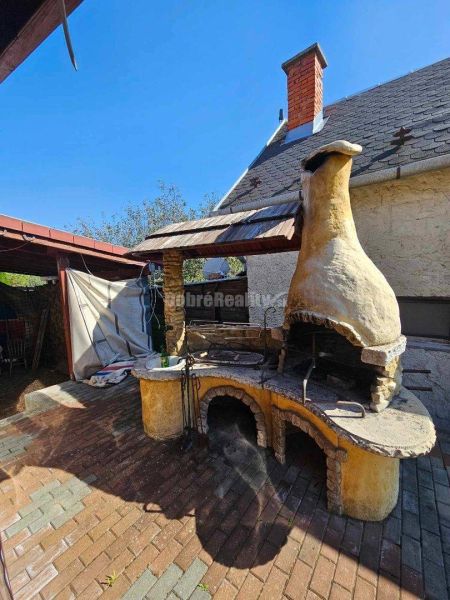 A family house in Malá Lehota with an outdoor stone fireplace in the yard.