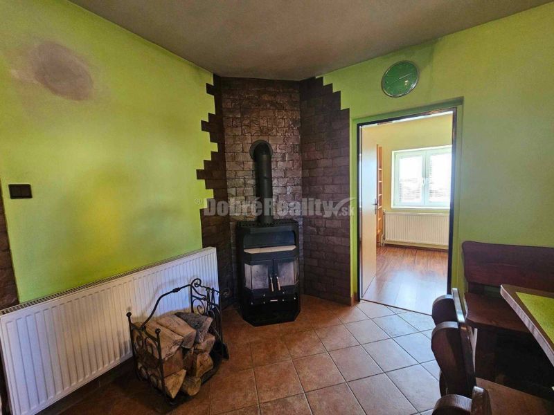 Living room in a family house with a fireplace, tiled stove, and wooden floor decor.