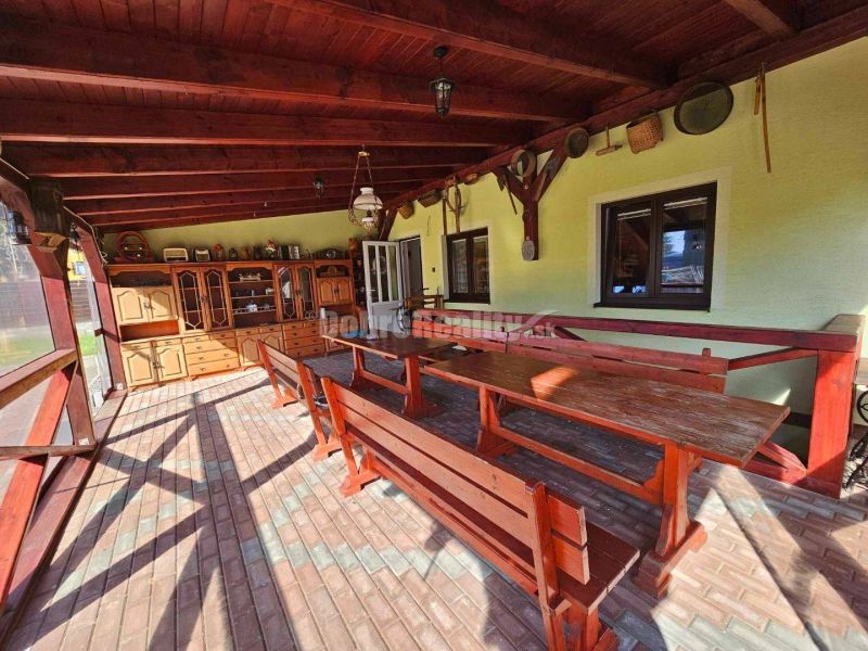 An outdoor terrace at a family house in Malá Lehota with wooden seating and decorations.