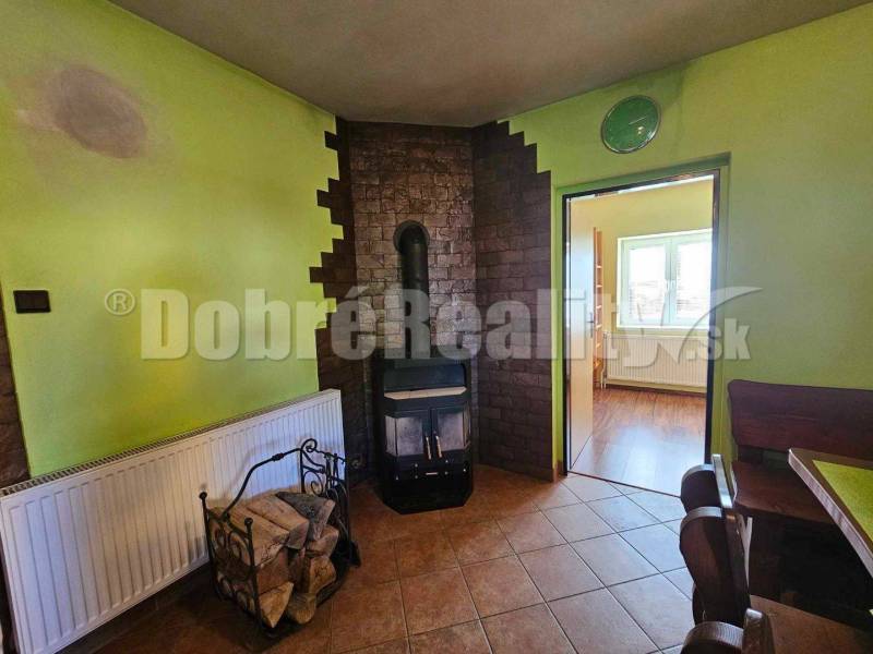 A family house with a fireplace stove, wood, and furniture in a cozy interior.