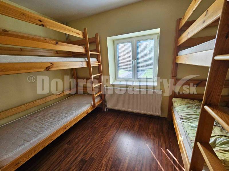 Wooden bunk beds in a room of a family house with a wooden floor.
