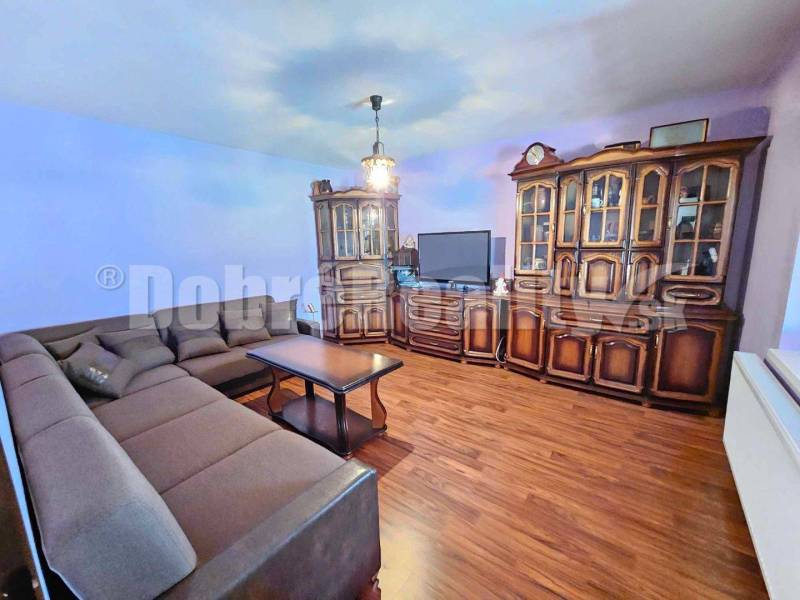 Living room in a family house with wooden furniture and a corner sofa.
