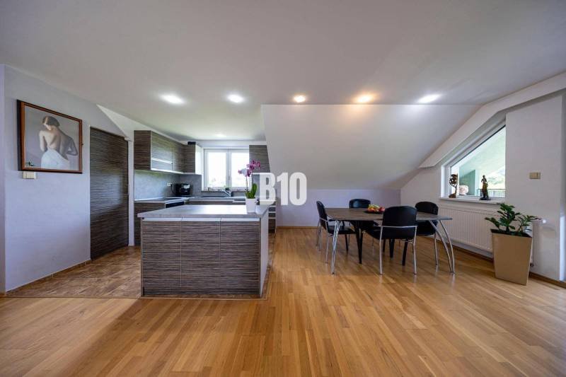 Kitchen with a dining table in a family house, wooden floor, large window.