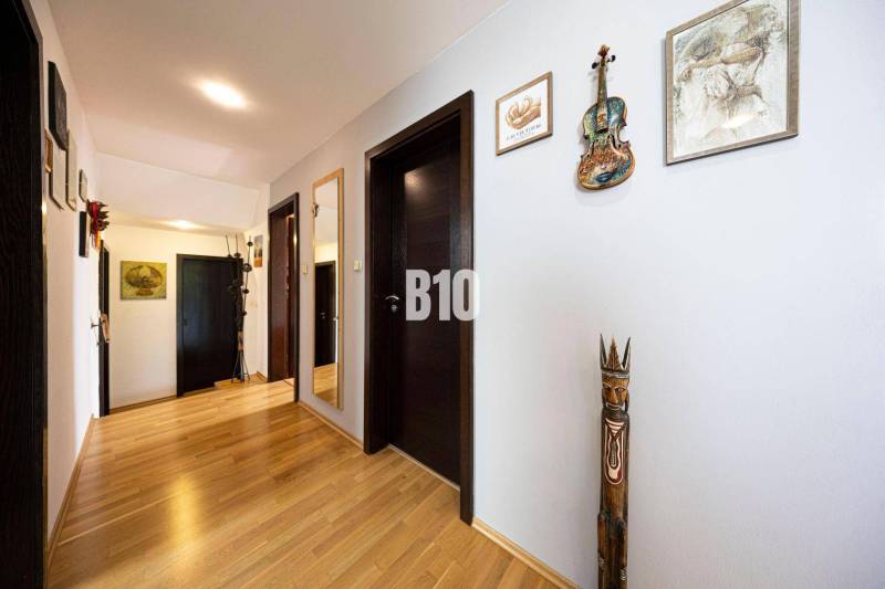 The interior of a family house with artistic decorations on light walls and wooden flooring.