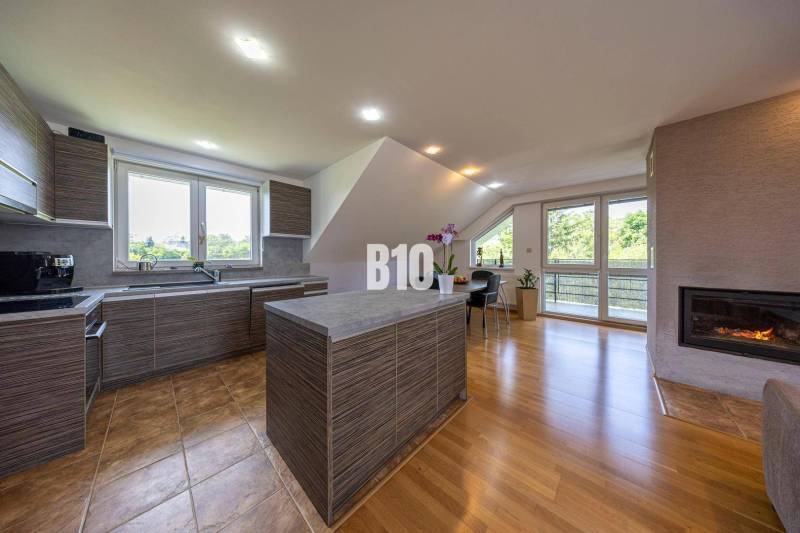 Interior of a family house with a kitchen island, windows, and a fireplace.