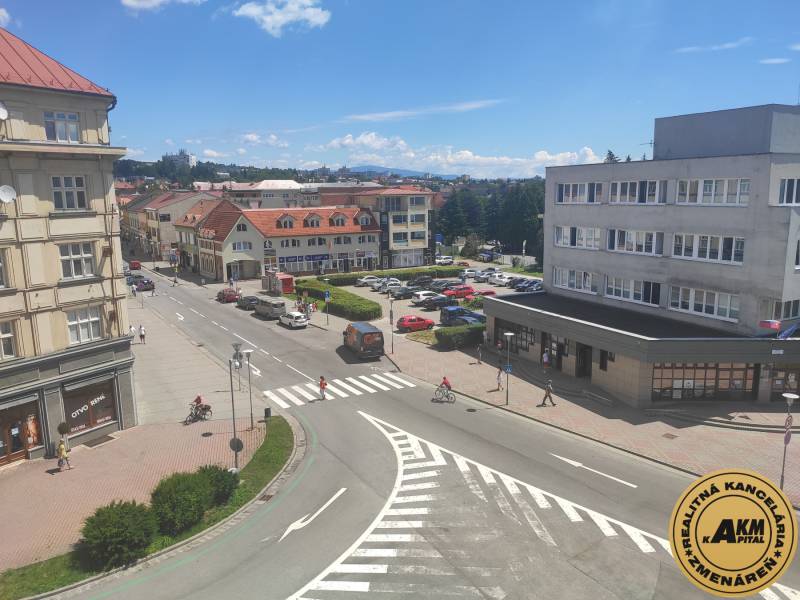 J. Kotáček Street in Zvolen with offices, shops, and cars in the parking lot.