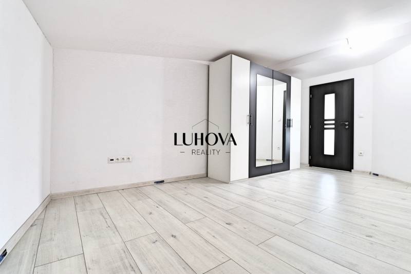 A bright room with a parquet floor and a wardrobe in a family house.