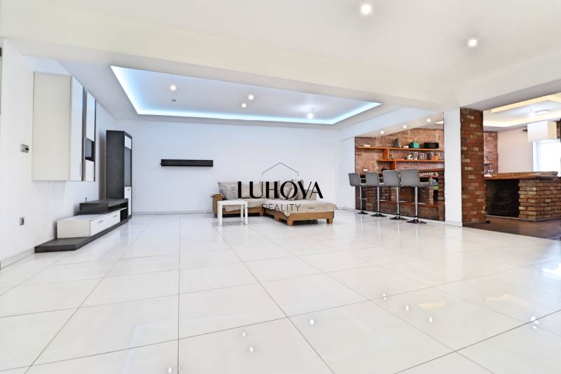 Interior of a family house with a spacious living room, bar stools, and seating furniture.