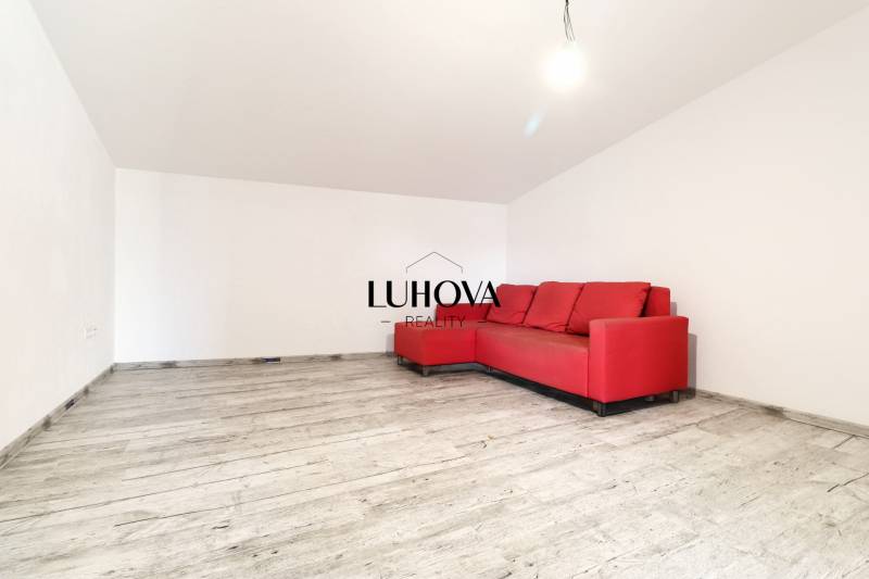A red couch in the living room on a wooden floor in a family house.