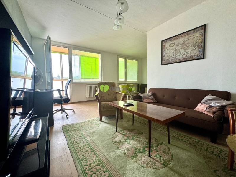 Living room in a 3-room apartment with dark furniture, a map, and a light floor.