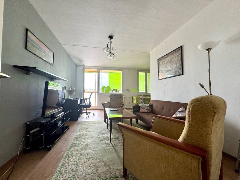 Living room in a 3-room apartment with a sofa, armchairs, and a television.