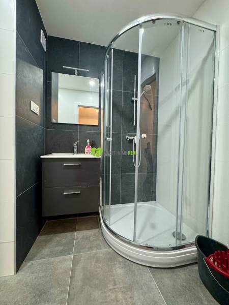 Bathroom with a shower and a mirror in a 3-room apartment.