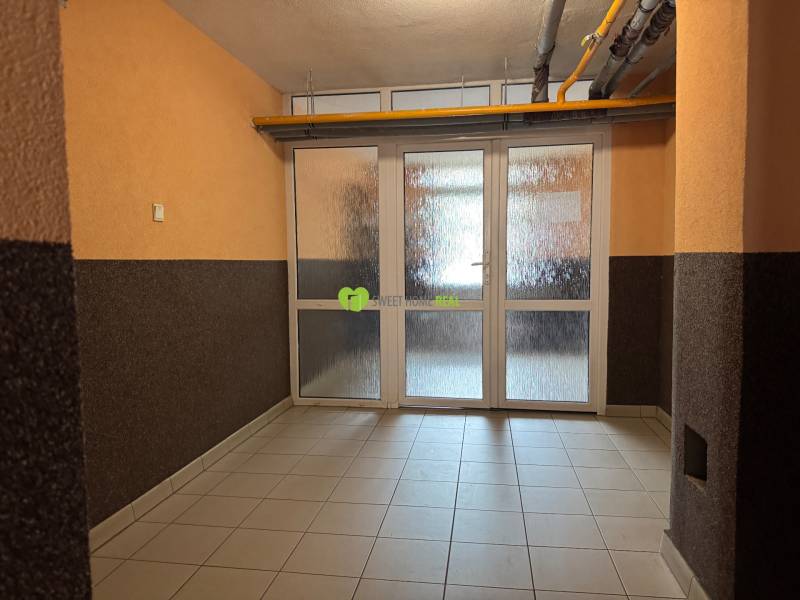 A hallway with glass doors in a 3-room apartment with brown walls.