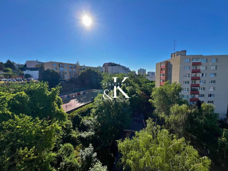 Sunny view of greenery and buildings from a 2-room apartment on Ladzianskeho in Bratislava.
