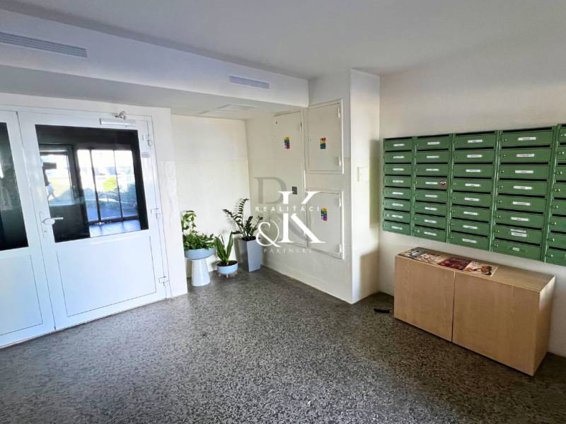 The entrance hall of a two-room apartment with mailboxes and plants in the corridor.
